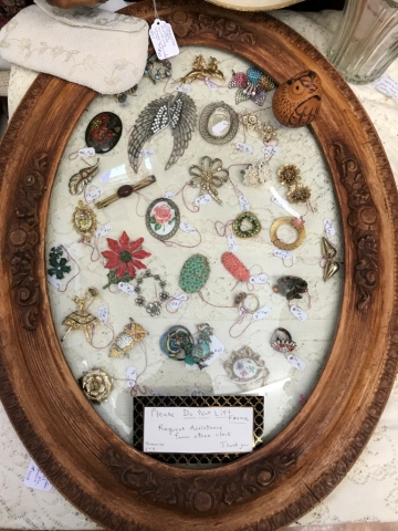 rhinestone and costume pins and brooches in oval display case