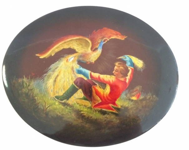 black oval Russian lacquer box with firebird and young man